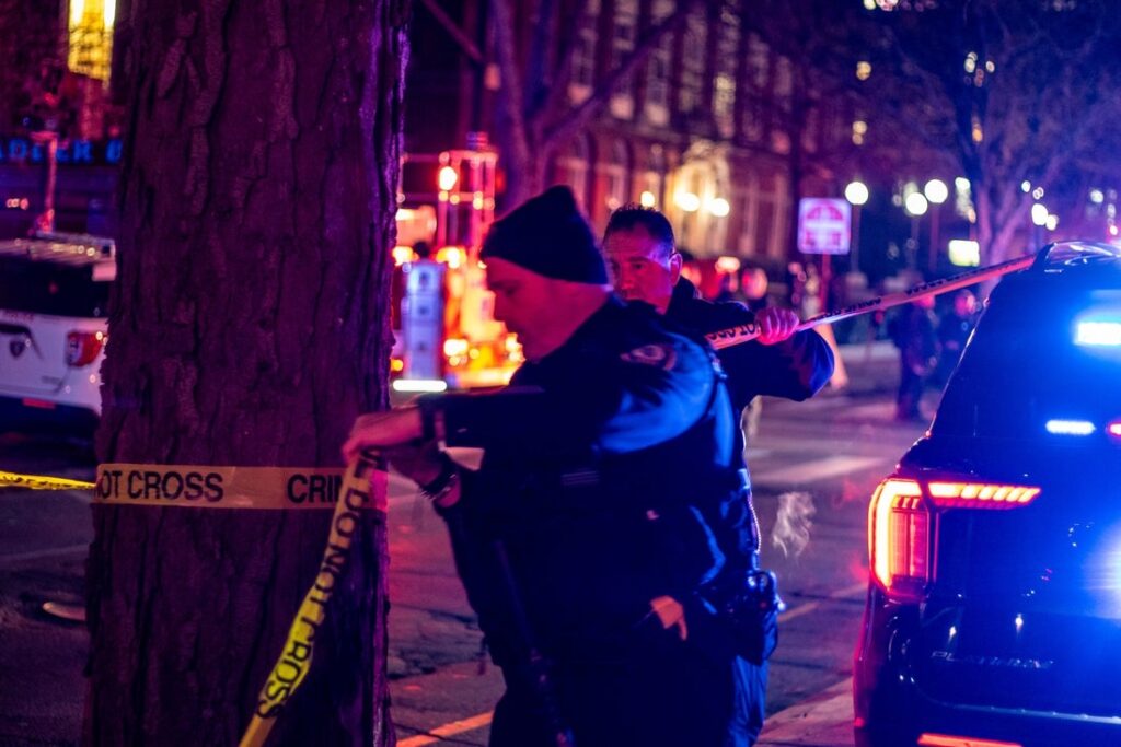 A police officer ties crime scene tape
