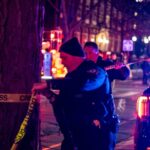 A police officer ties crime scene tape