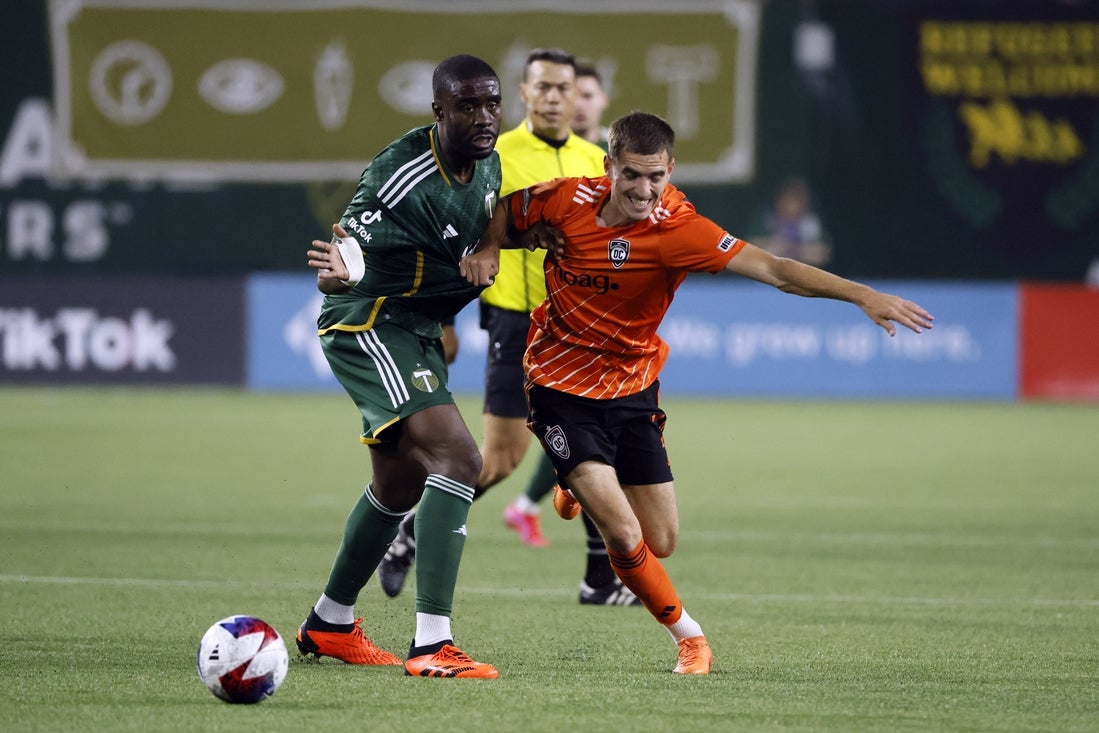 Apr 26, 2023; Portland, OR, USA; Orange County SC forward Milan Iloski (7) battles for the ball with Portland Timbers defender Larrys Mabiala (33) during the second half at Providence Park. Mandatory Credit: Soobum Im-Imagn Images