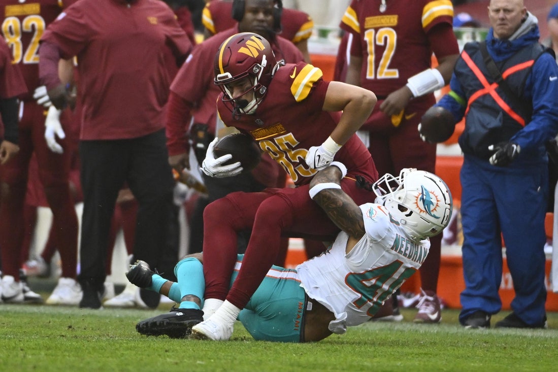 Dec 3, 2023; Landover, Maryland, USA; Washington Commanders tight end Cole Turner (85) is tackled by Miami Dolphins cornerback Nik Needham (40) during the second half at FedExField. Mandatory Credit: Brad Mills-Imagn Images