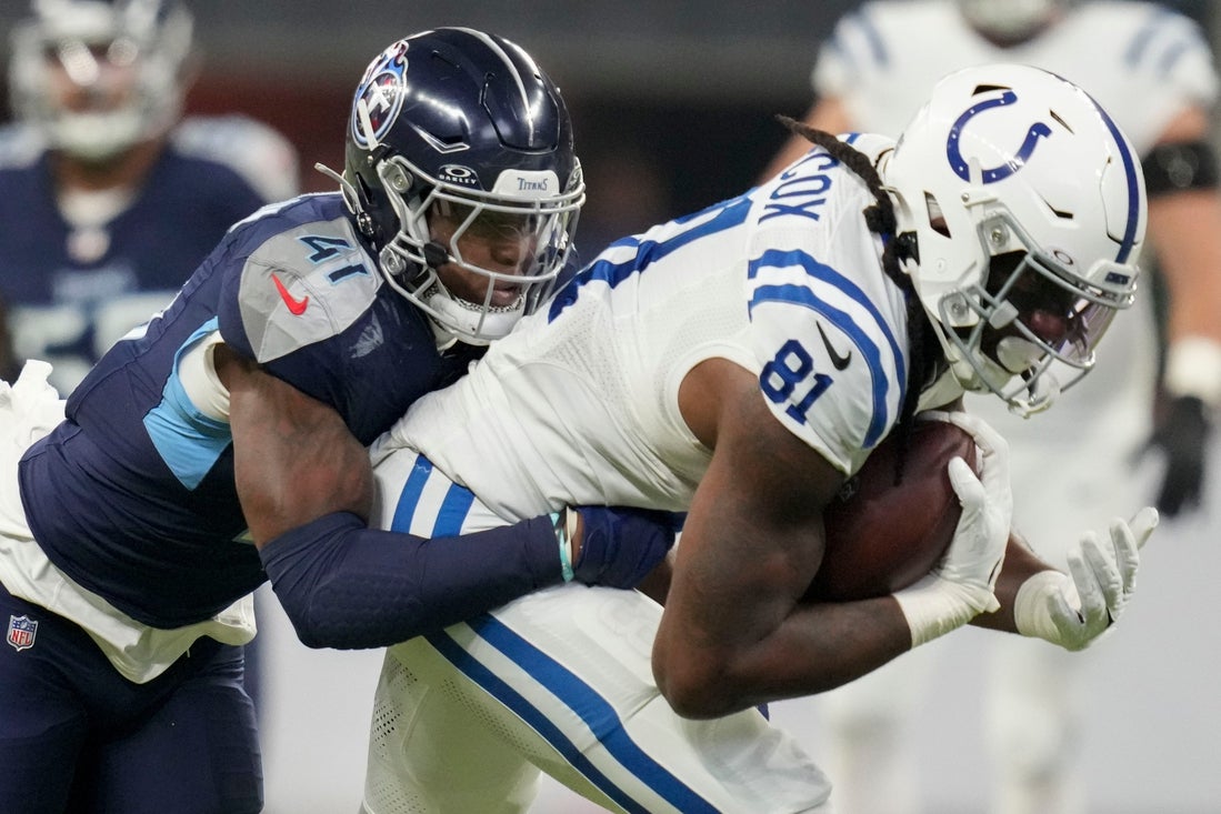 Tennessee Titans linebacker Otis Reese IV (41) tackles Indianapolis Colts tight end Mo Alie-Cox (81) on Sunday, Dec. 22, 2024, during a game against the Tennessee Titans at Lucas Oil Stadium in Indianapolis.