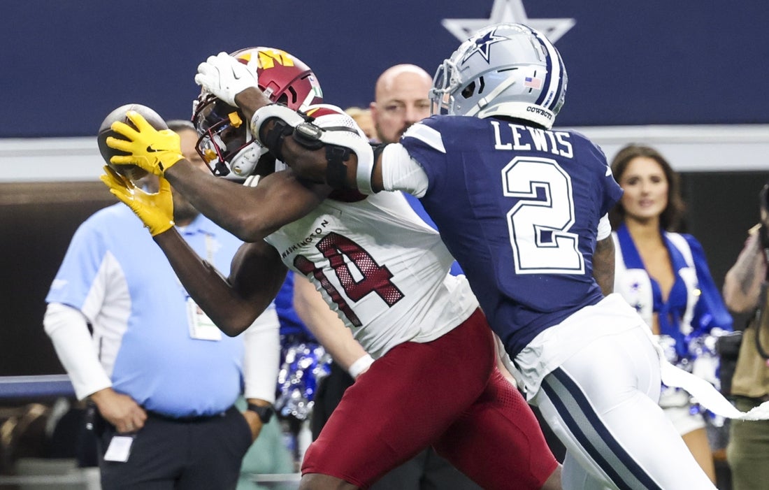 Jan 5, 2025; Arlington, Texas, USA; Washington Commanders wide receiver Olamide Zaccheaus (14) makes a catch over Dallas Cowboys cornerback Jourdan Lewis (2) during the second half at AT&T Stadium. Mandatory Credit: Kevin Jairaj-Imagn Images