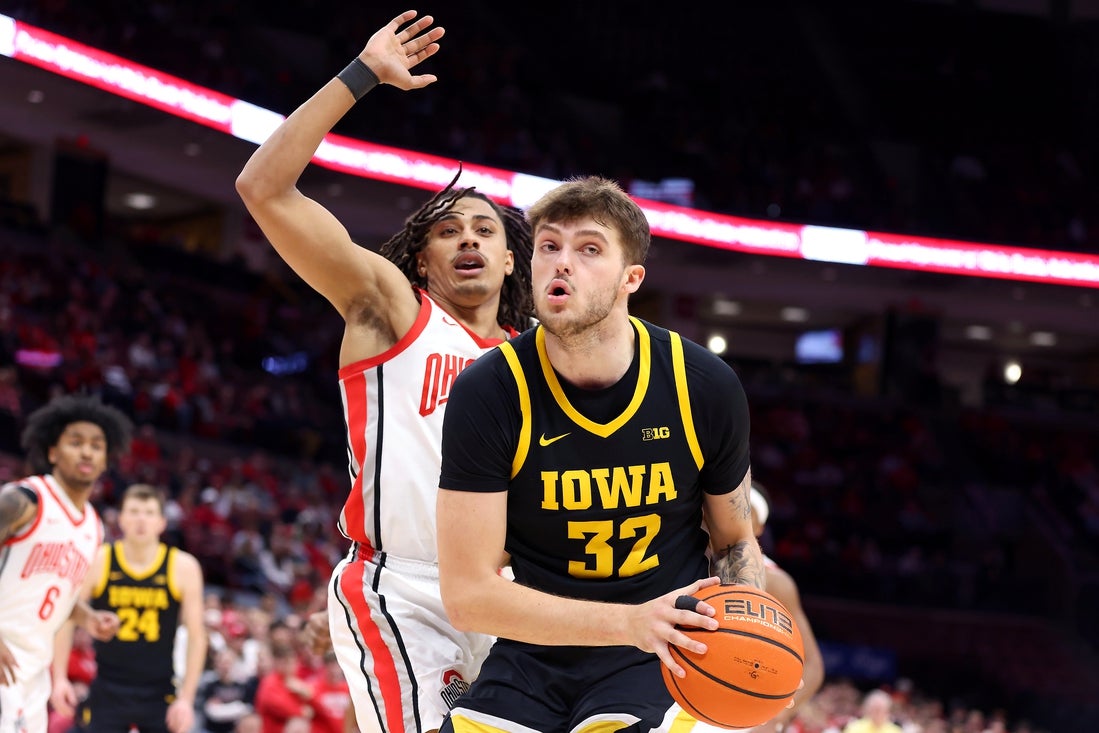 Jan 27, 2025; Columbus, Ohio, USA; Iowa Hawkeyes forward Owen Freeman (32) controls the ball as Ohio State Buckeyes forward Devin Royal (21) defends during the first half at Value City Arena. Mandatory Credit: Joseph Maiorana-Imagn Images