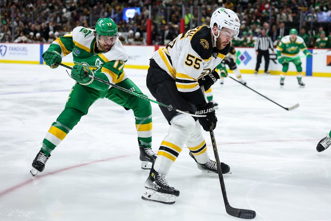 Mar 2, 2025; Saint Paul, Minnesota, USA; Boston Bruins right wing Justin Brazeau (55) skates with the puck as Minnesota Wild left wing Marcus Foligno (17) defends during the third period at Xcel Energy Center. Mandatory Credit: Matt Krohn-Imagn Images