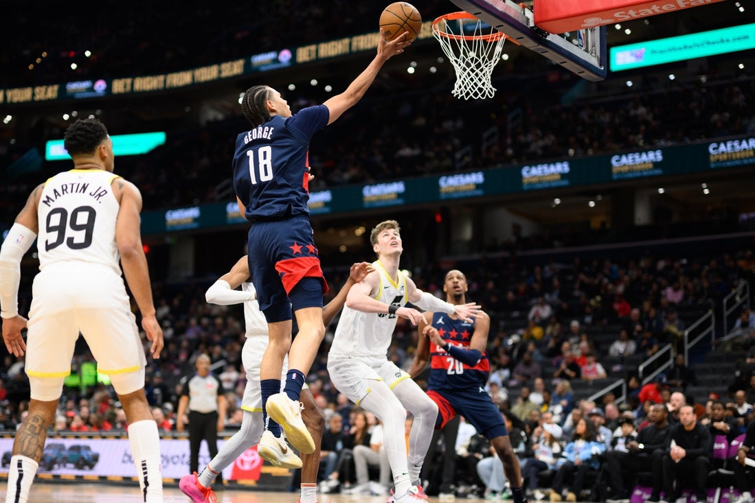 Mar 5, 2025; Washington, District of Columbia, USA; Washington Wizards forward Kyshawn George (18) drives to the basket against Utah Jazz forward KJ Martin (99) during the second quarter at Capital One Arena. Mandatory Credit: Reggie Hildred-Imagn Images