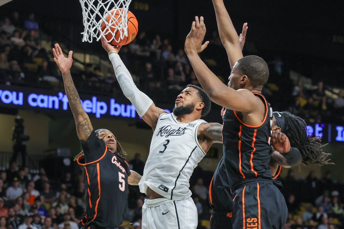 Mar 5, 2025; Orlando, Florida, USA; UCF Knights guard Darius Johnson (3) goes to the basket against Oklahoma State Cowboys guard Khalil Brantley (5) during the second half at Addition Financial Arena. Mandatory Credit: Mike Watters-Imagn Images
