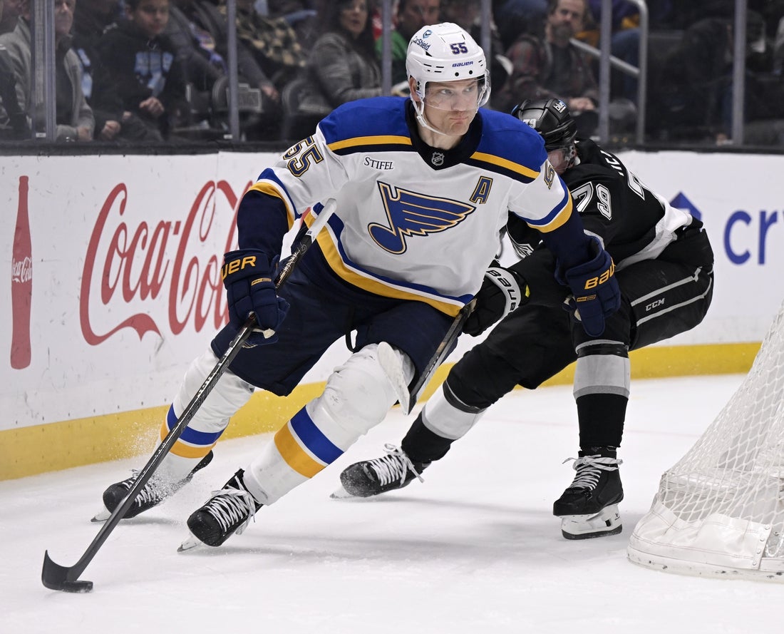 Mar 5, 2025; Los Angeles, California, USA; St. Louis Blues defenseman Colton Parayko (55) controls the puck past Los Angeles Kings center Samuel Helenius (79) during the second period at Crypto.com Arena. Mandatory Credit: Alex Gallardo-Imagn Images