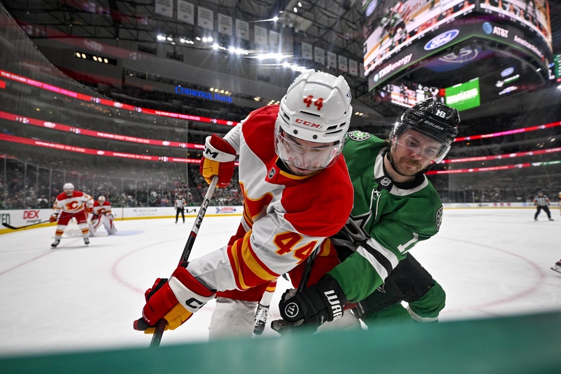 Mar 6, 2025; Dallas, Texas, USA; Calgary Flames defenseman Joel Hanley (44) and Dallas Stars center Sam Steel (18) battle for control of the puck during the second period at the American Airlines Center. Mandatory Credit: Jerome Miron-Imagn Images