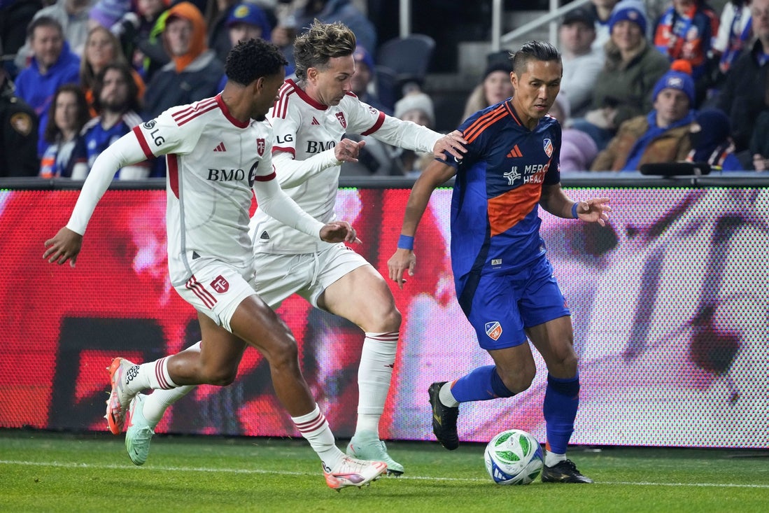 Mar 8, 2025; Cincinnati, Ohio, USA; FC Cincinnati forward Yuya Kubo (7) dribbles down the sideline as Toronto FC midfielder Kosi Thompson (6), left, and forward Federico Bernardeschi (10), center, defend during the first half of match at TQL Stadium. Mandatory Credit: Kareem Elgazzar-Imagn Images