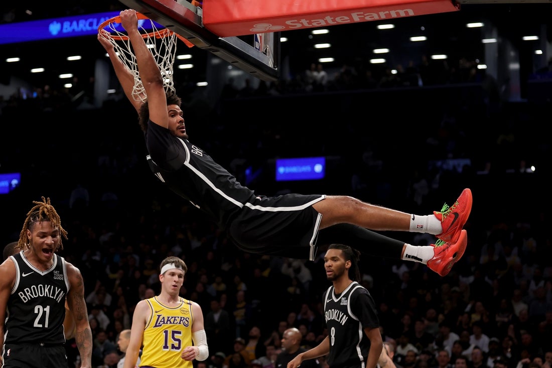 Mar 10, 2025; Brooklyn, New York, USA; Brooklyn Nets forward Cameron Johnson (2) hangs on the rim after a dunk against the Los Angeles Lakers during the fourth quarter at Barclays Center. Mandatory Credit: Brad Penner-Imagn Images
