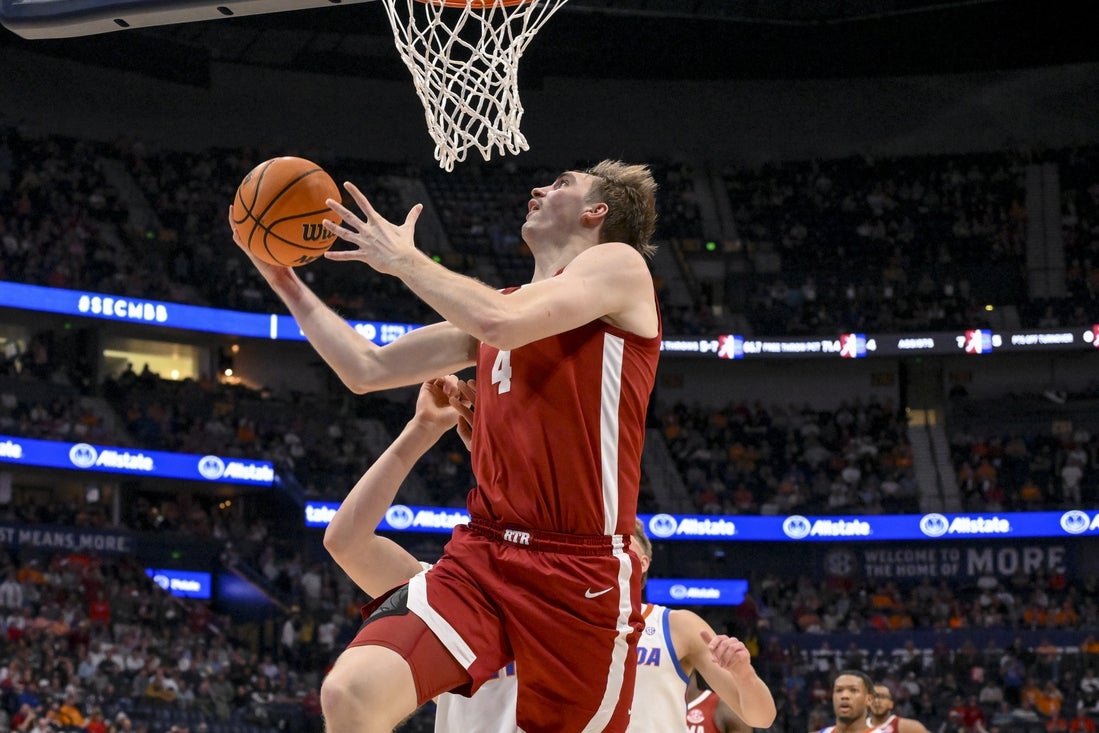 Mar 15, 2025; Nashville, TN, USA; Alabama Crimson Tide forward Grant Nelson (4) lays the ball in over Florida Gators forward Alex Condon (21) during the first half at Bridgestone Arena. Mandatory Credit: Steve Roberts-Imagn Images