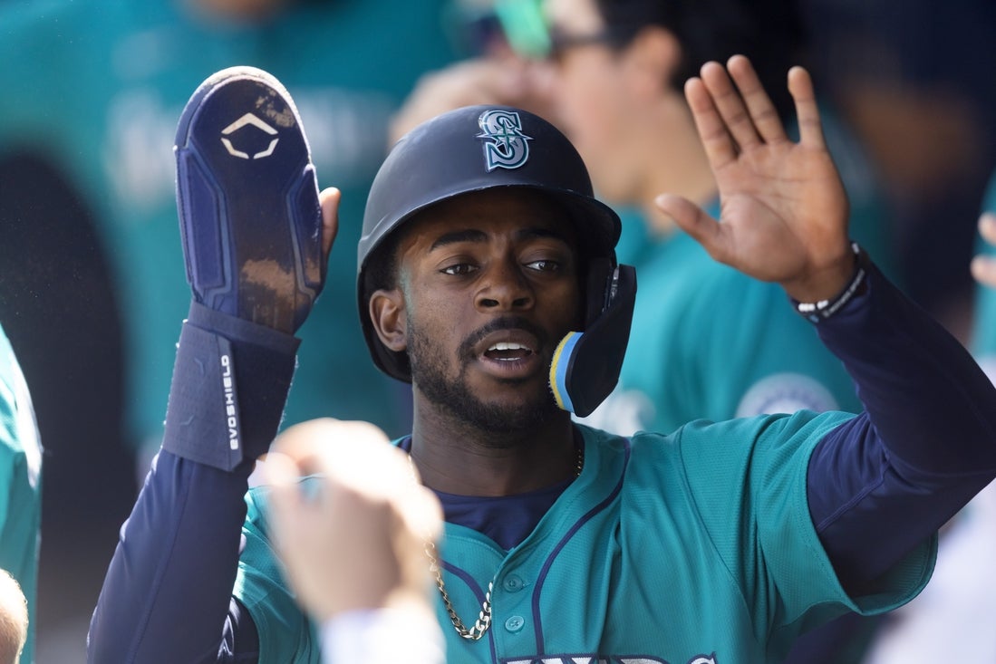 Mar 15, 2025; Peoria, Arizona, USA; Seattle Mariners infielder Ryan Bliss celebrates with teammates in the dugout after scoring against the San Diego Padres during a spring training game at Peoria Sports Complex. Mandatory Credit: Mark J. Rebilas-Imagn Images