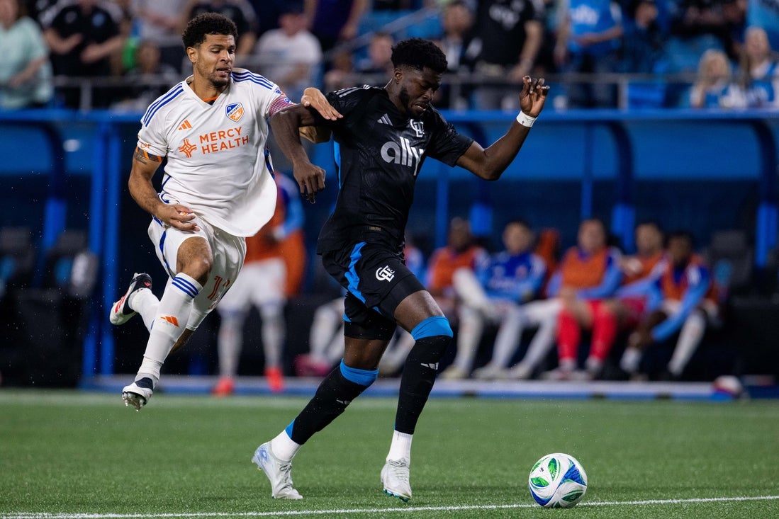 Mar 15, 2025; Charlotte, North Carolina, USA; FC Cincinnati defender Miles Robinson (12) chases Charlotte FC forward Patrick Agyemang (33) during the first half at Bank of America Stadium. Mandatory Credit: Scott Kinser-Imagn Images