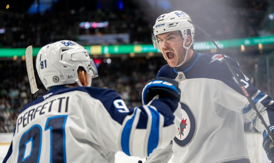 Mar 16, 2025; Seattle, Washington, USA; Winnipeg Jets defenseman Dylan Samberg (54) celebrates scoring a goal forward Cole Perfetti (91) against the Seattle Kraken during overgtime at Climate Pledge Arena. Mandatory Credit: Stephen Brashear-Imagn Images