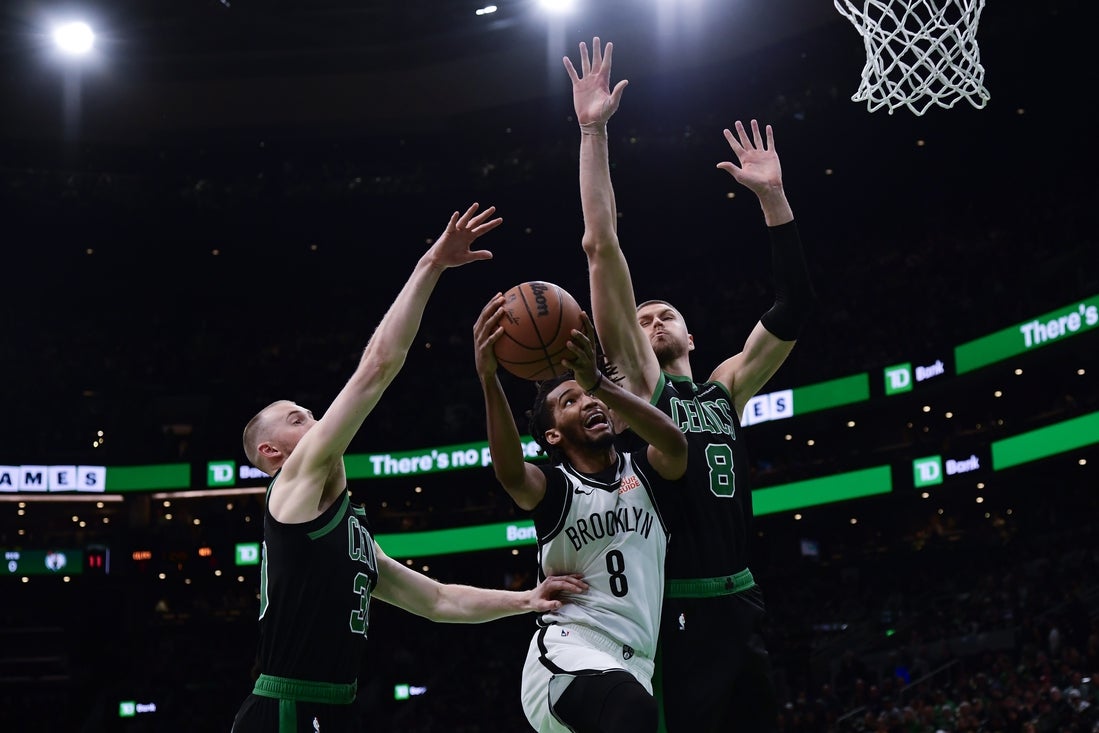 Mar 18, 2025; Boston, Massachusetts, USA; Brooklyn Nets forward Ziaire Williams (8) drives to the basket while Boston Celtics center Kristaps Porzingis (8) defends during the first half at TD Garden. Mandatory Credit: Bob DeChiara-Imagn Images
