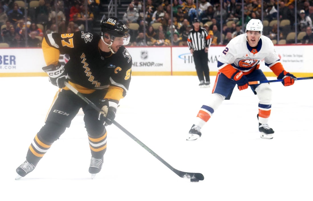 Mar 18, 2025; Pittsburgh, Pennsylvania, USA; Pittsburgh Penguins center Sidney Crosby (87) skates with the puck against the New York Islanders during the first period at PPG Paints Arena. Mandatory Credit: Charles LeClaire-Imagn Images