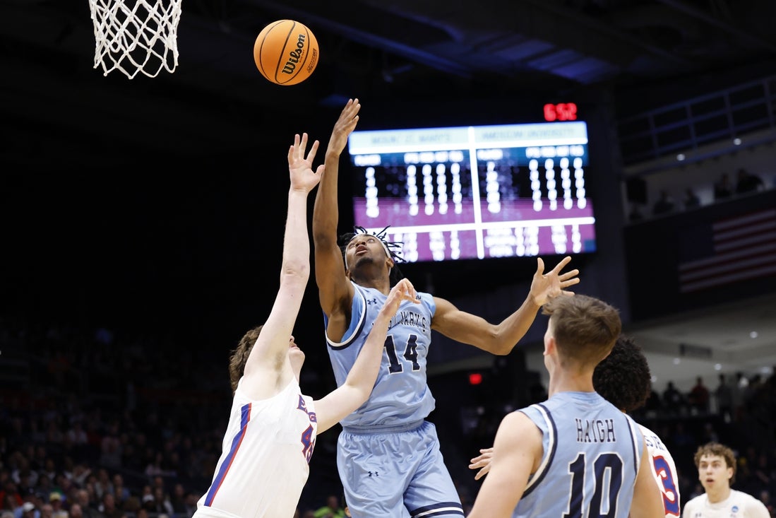 Mar 19, 2025; Dayton, OH, USA; Mount St. Mary's Mountaineers forward Jedy Cordilia (14) shoots the ball over American University Eagles forward Mason Whittaker (45) in the first half at UD Arena. Mandatory Credit: Rick Osentoski-Imagn Images