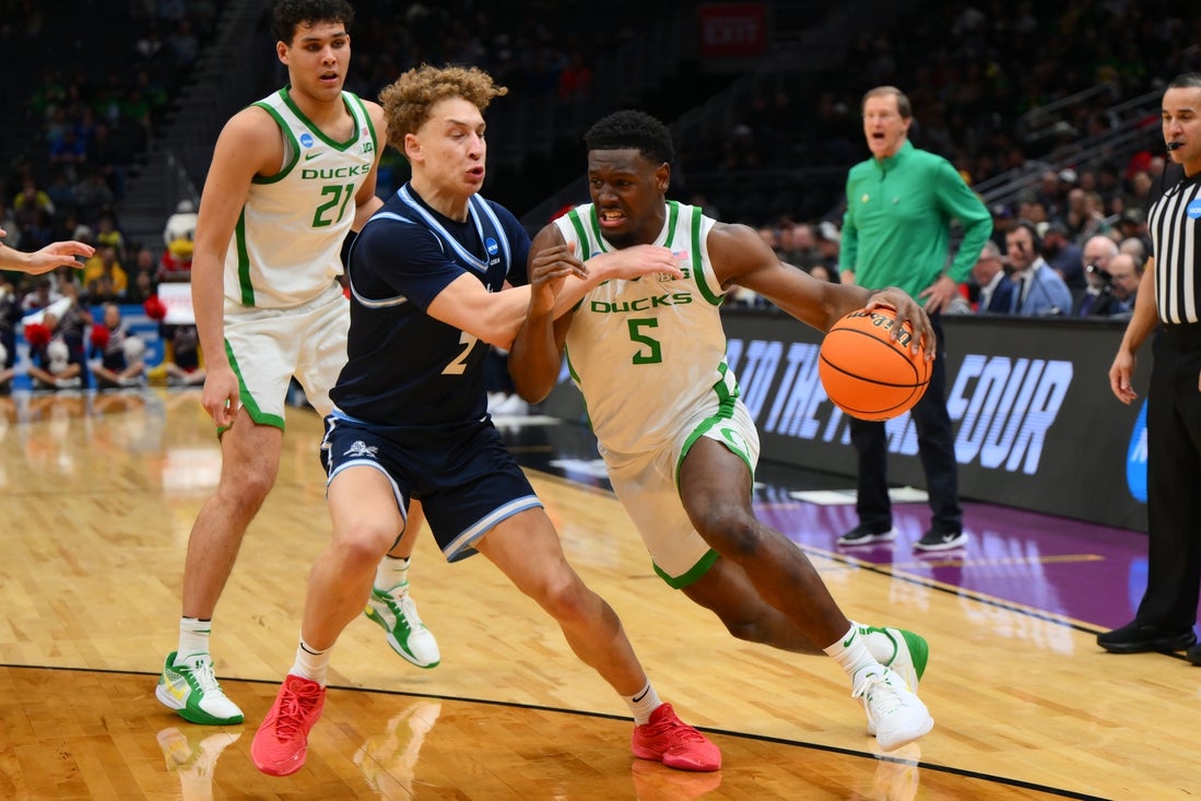 Mar 21, 2025; Seattle, WA, USA; Oregon Ducks guard TJ Bamba (5) dribbles the ball past Liberty Flames guard Taelon Peter (2) during the second half in the first round of the NCAA Tournament at Climate Pledge Arena. Mandatory Credit: Steven Bisig-Imagn Images