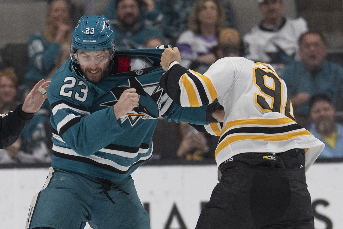 Mar 22, 2025; San Jose, California, USA; San Jose Sharks right wing Barclay Goodrow (23) and Boston Bruins center Jakub Lauko (94) fight during the first period at SAP Center at San Jose. Mandatory Credit: Stan Szeto-Imagn Images