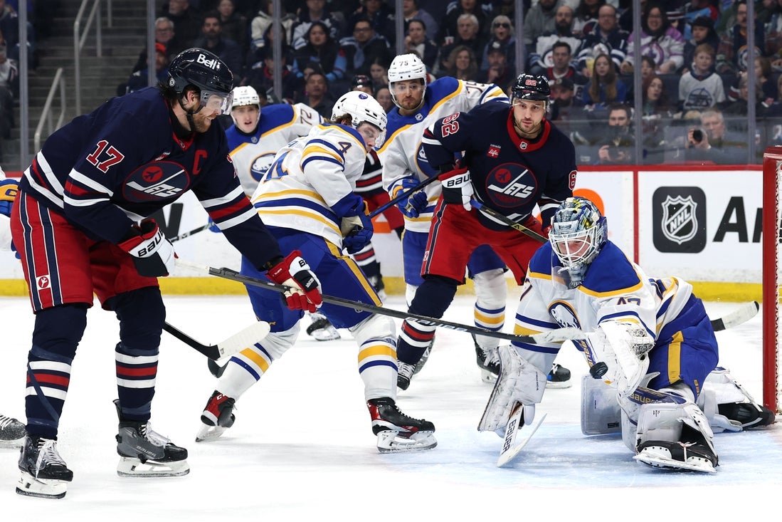 Mar 23, 2025; Winnipeg, Manitoba, CAN; Winnipeg Jets center Adam Lowry (17) shoots on Buffalo Sabres goaltender James Reimer (47) in the second period at Canada Life Centre. Mandatory Credit: James Carey Lauder-Imagn Images