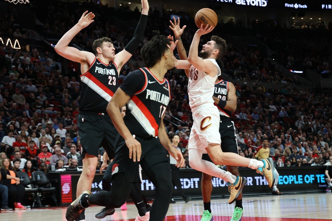 Mar 25, 2025; Portland, Oregon, USA; Cleveland Cavaliers guard Ty Jerome (2) shoots the ball over Portland Trail Blazers center Donovan Clingan (23) and guard Shaedon Sharpe (17) in the first half at Moda Center. Mandatory Credit: Jaime Valdez-Imagn Images
