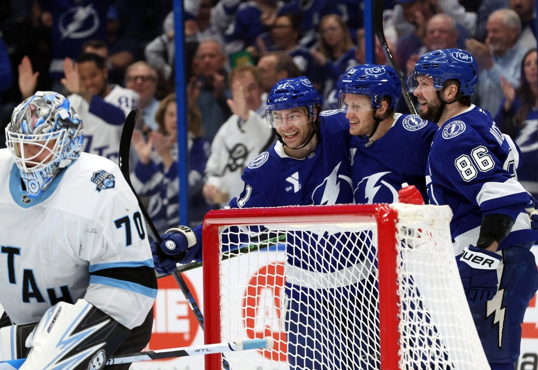 Mar 27, 2025; Tampa, Florida, USA; Tampa Bay Lightning center Jake Guentzel (59) is congratulated by right wing Nikita Kucherov (86) and center Brayden Point (21) after he scored on Utah Hockey Club goaltender Karel Vejmelka (70) during the first period at Amalie Arena. Mandatory Credit: Kim Klement Neitzel-Imagn Images