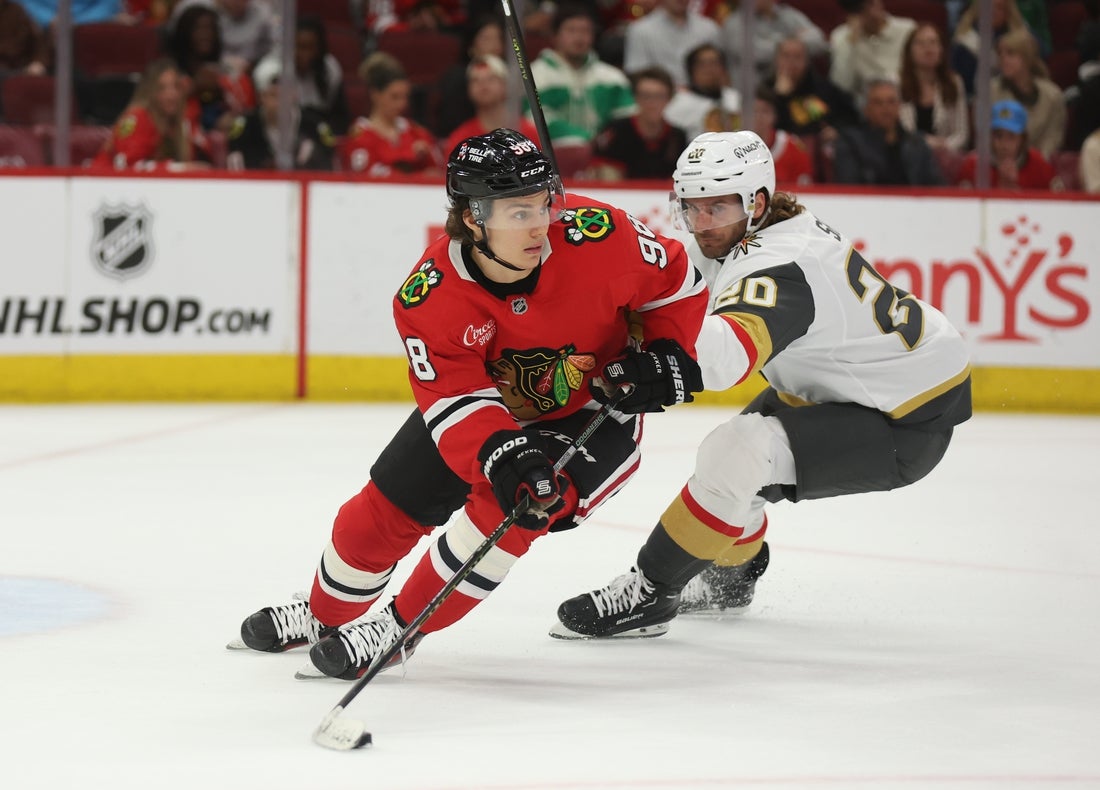 Mar 28, 2025; Chicago, Illinois, USA; Chicago Blackhawks center Connor Bedard (98) and Vegas Golden Knights left wing Brandon Saad (20) battle for control of the puck during the second period at United Center. Mandatory Credit: Talia Sprague-Imagn Images