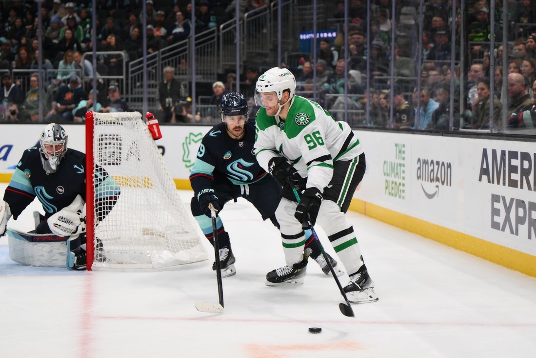 Mar 31, 2025; Seattle, Washington, USA; Dallas Stars right wing Mikko Rantanen (96) plays the puck while defended by Seattle Kraken center Chandler Stephenson (9) during the first period at Climate Pledge Arena. Mandatory Credit: Steven Bisig-Imagn Images