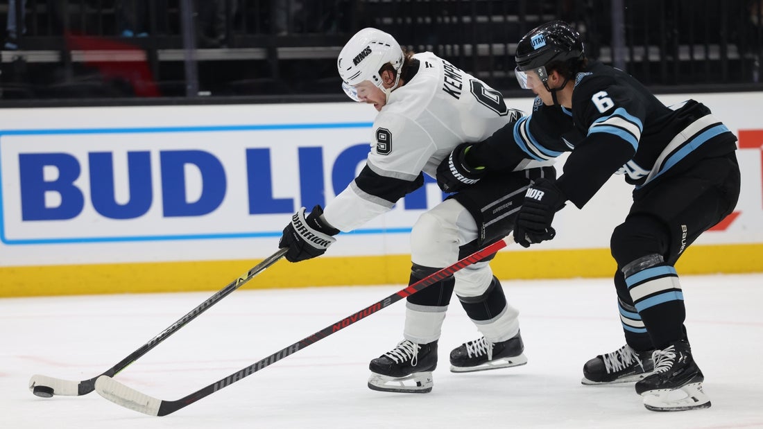 Apr 3, 2025; Salt Lake City, Utah, USA; Los Angeles Kings right wing Adrian Kempe (9) controls the puck against Utah Hockey Club defenseman John Marino (6) during the first period at Delta Center. Mandatory Credit: Rob Gray-Imagn Images