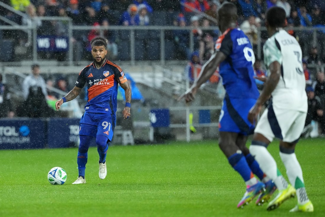 Apr 5, 2025; Cincinnati, Ohio, USA; FC Cincinnati defender DeAndre Yedlin (91) looks to pass the ball forward to forward Kevin Denkey (9) during there first half against the New England Revolution at TQL Stadium. Mandatory Credit: Kareem Elgazzar-Imagn Images