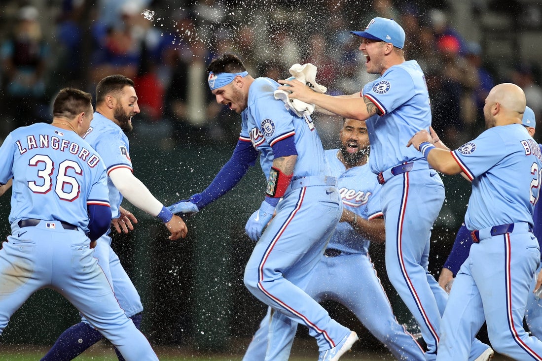 Apr 6, 2025; Arlington, Texas, USA; Texas Rangers catcher Jonah Heim (28) and his teammates celebrate after he singled in the winning run in the bottom of the ninth inning against the Tampa Bay Rays at Globe Life Field. Mandatory Credit: Tim Heitman-Imagn Images