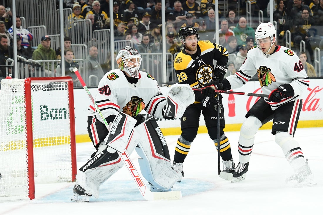 Apr 10, 2025; Boston, Massachusetts, USA; Boston Bruins center Elias Lindholm (28) follows the play in front of Chicago Blackhawks goaltender Arvid Soderblom (40) while defenseman Louis Crevier (46) defends during the first period at TD Garden. Mandatory Credit: Bob DeChiara-Imagn Images