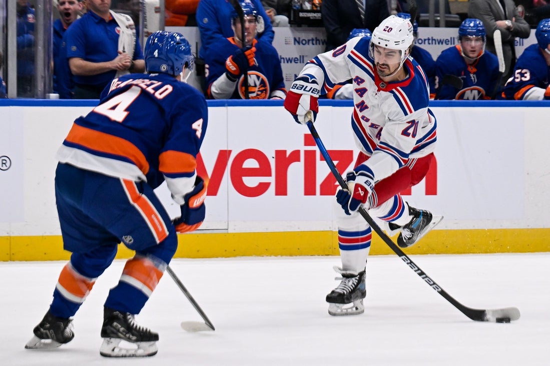 Apr 10, 2025; Elmont, New York, USA; New York Rangers left wing Chris Kreider (20) attempts a shot defended by New York Islanders defenseman Tony DeAngelo (4) during the first period at UBS Arena. Mandatory Credit: Dennis Schneidler-Imagn Images