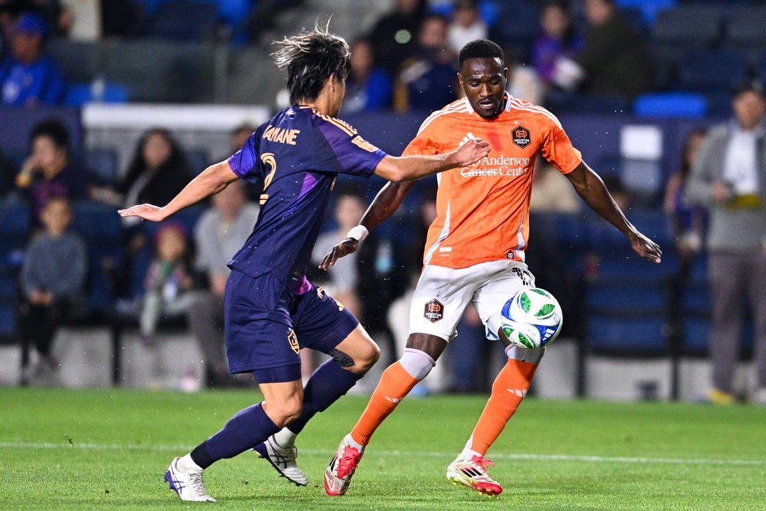 Apr 12, 2025; Carson, California, USA; Houston Dynamo FC forward Ibrahim Aliyu (18) moves the ball against LA Galaxy defender Miki Yamane (2) during the second half at Dignity Health Sports Park. Mandatory Credit: Kelvin Kuo-Imagn Images