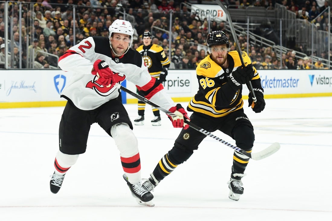 Apr 15, 2025; Boston, Massachusetts, USA; New Jersey Devils defenseman Brian Dumoulin (2) and Boston Bruins right wing David Pastrnak (88) skates after the puck during the first period at TD Garden. Mandatory Credit: Bob DeChiara-Imagn Images