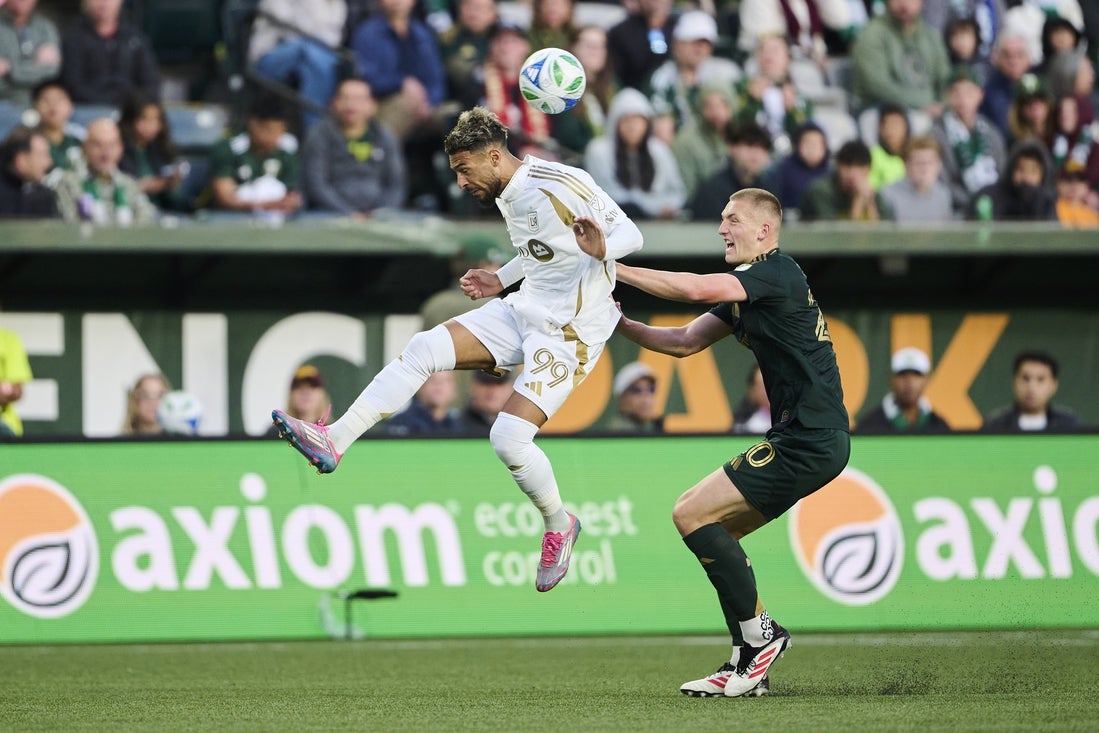 Apr 19, 2025; Portland, Oregon, USA; Los Angeles FC forward Denis Bouanga (99) heads the ball during the first half against Portland Timbers defender Finn Surman (20) at Providence Park. Mandatory Credit: Troy Wayrynen-Imagn Images