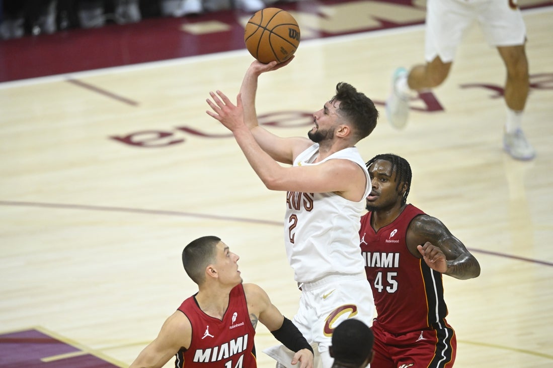 Apr 20, 2025; Cleveland, Ohio, USA; Cleveland Cavaliers guard Ty Jerome (2) shoots between Miami Heat guard Tyler Herro (14) and guard Davion Mitchell (45) in the fourth quarter at Rocket Arena. Mandatory Credit: David Richard-Imagn Images