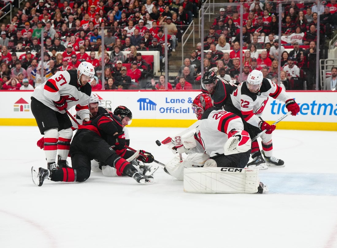 Apr 29, 2025; Raleigh, North Carolina, USA; New Jersey Devils goaltender Jacob Markstrom (25) and center Justin Dowling (37) stops the scoring attempt buy Carolina Hurricanes right wing Andrei Svechnikov (37) during the first period in game five of the first round of the 2025 Stanley Cup Playoffs at Lenovo Center. Mandatory Credit: James Guillory-Imagn Images