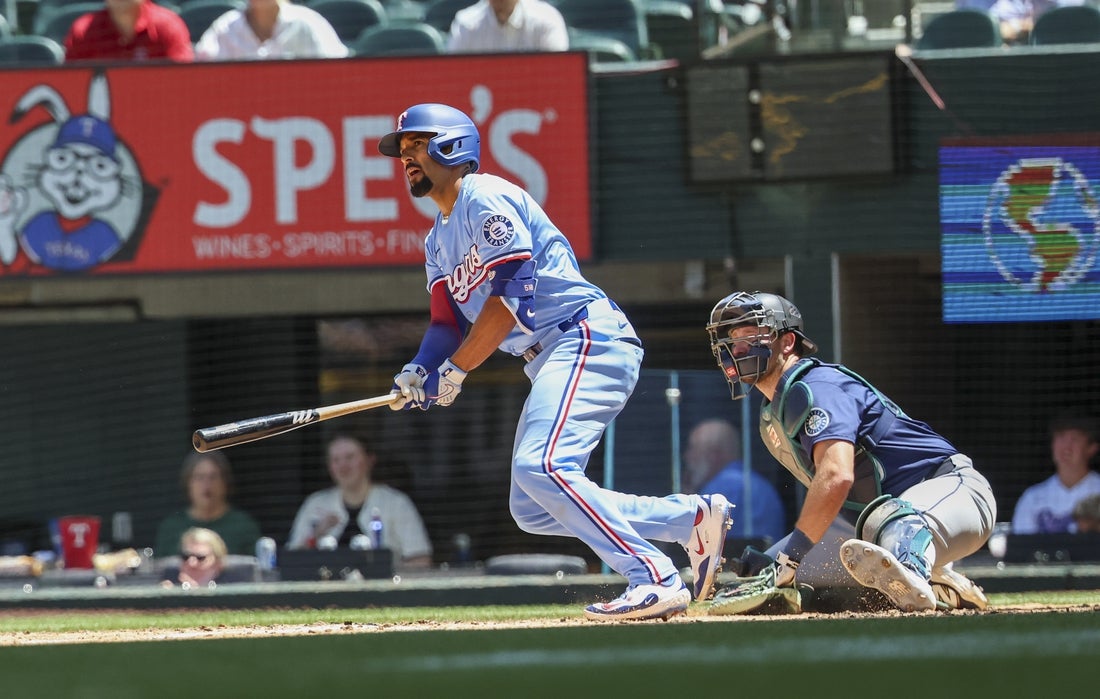 May 4, 2025; Arlington, Texas, USA; Texas Rangers shortstop Corey Seager (5) hits an rbi single during the third inning against the Seattle Mariners at Globe Life Field. Mandatory Credit: Kevin Jairaj-Imagn Images